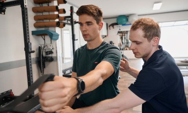 Nils Kleser behandelt einen männlichen Patienten an der Schulter